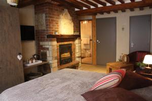 a bedroom with a bed and a brick fireplace at Les Songes d'Héléna in Honfleur