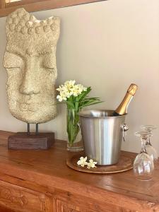 una mesa con una estatua de una cabeza y un jarrón de flores en La Playa, en Los Órganos