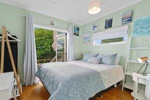 a bedroom with a bed and a window at Lakefront Treasure - Lakefront Rotomā Holiday Home in Rotorua
