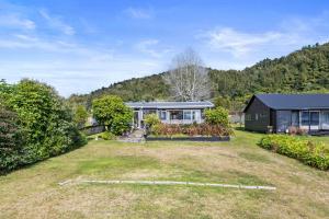 una casa con un grande cortile di fronte di Lakefront Treasure - Lakefront Rotomā Holiday Home a Rotorua