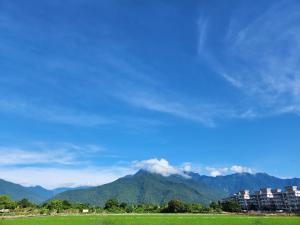 un campo verde con montañas al fondo en Najima B&B en Jian