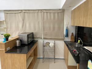 a small kitchen with a sink and a microwave at House near Suvarnabhumi Airport in Ban Hua Takhe