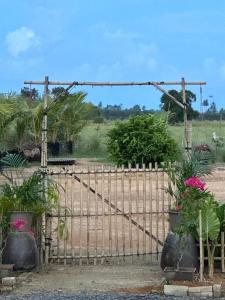 an iron gate with plants in front of a field at DeAsmarra Homestay in Tanjung Piandang +15 photos
