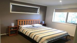 - une chambre avec un lit et une fenêtre dans l'établissement 24 Kangaroo Run Tura Beach, à Tura Beach