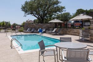 a pool with tables and chairs and a table and chairs at Towneplace Suites By Marriott Austin North/Lakeline in Cedar Park