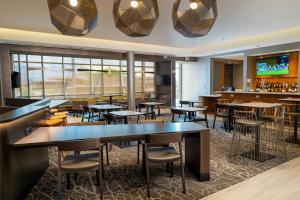 a restaurant with tables and chairs and a bar at SpringHill Suites Spokane Airport in Spokane