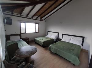 een kamer met twee bedden en een tafel erin bij Hotel Artemisa in Sutamarchán