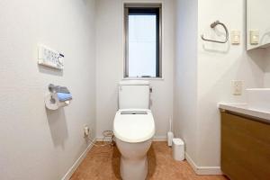 a bathroom with a white toilet and a window at Luce Takanawa in Tokyo