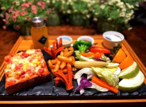 a plate of food with vegetables and a slice of pizza at Kenting My Home in Kenting