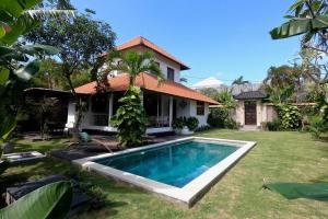 a house with a swimming pool in the yard at Villa Santai in Seminyak