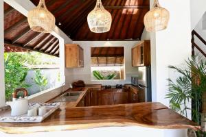 a kitchen with a wooden counter top and pendant lights at Villa Santai in Seminyak