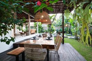 a dining room table and chairs in a garden at Villa Santai in Seminyak