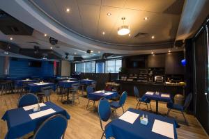 una sala da pranzo con tavoli e sedie blu di Hotel du Fjord a Saguenay