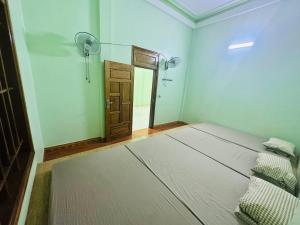 a room with a bed and a door and a mirror at A Páo Hostel Mộc Châu in Mộc Châu