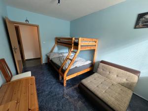 Zimmer mit einem Etagenbett, einem Sofa und einem Stuhl in der Unterkunft Apartmán Harrachov in Harrachov