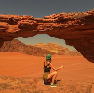 a woman sitting on a rock in the desert at Bedouin bunch camp in Wadi Rum