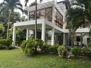 a large white house with glass windows and trees at R Degrees Villa - Nawala in Nawala