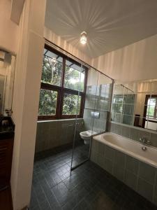 a bathroom with a tub and a toilet and a sink at R Degrees Villa - Nawala in Nawala