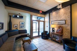 - une salle d'attente avec un canapé, une table et des chaises dans l'établissement Hotel du Fjord, à Saguenay