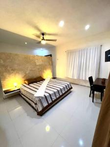 ein Schlafzimmer mit einem Bett und einem Tisch darin in der Unterkunft La Casona del Tío in Mérida