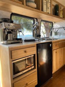 una cocina con microondas y fregadero en una cabaña en Sal & Turq, en Roatan
