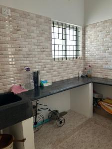 a kitchen with a counter top and a brick wall at Sambrama in Bangalore