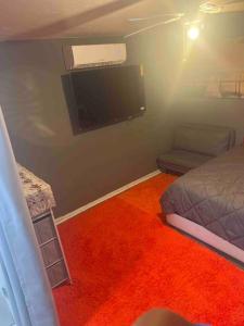a bedroom with a bed and a flat screen tv at Backyard Guesthouse in Miami Gardens
