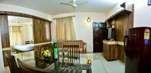 a living room with a table with a bottle of wine at La Grace Resort in Benaulim