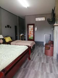 twee bedden in een kamer met houten vloeren bij Yotin Guest House in Trat