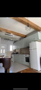 a kitchen with a white refrigerator and a stove at modern rustic house in the heart Of the village in Kefalos