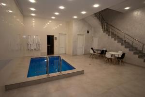a swimming pool in a room with a table and chairs at Happy home in Tsaghkadzor