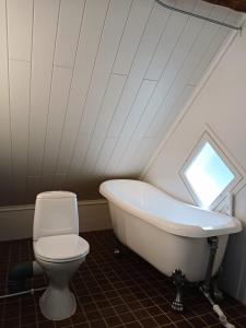 a bathroom with a white tub and a toilet at The House in Lahti