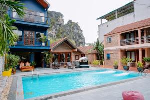a house with a swimming pool in front of a building at Chez Loan Hotel in Ninh Binh