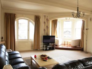 a living room with a couch and a tv at Royal Mile Mansions Apartment Edinburgh in Edinburgh