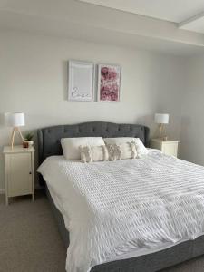 a bedroom with a large bed with two night stands at Designer 1 BR Apt in Wollongong with Ocean Views in Wollongong