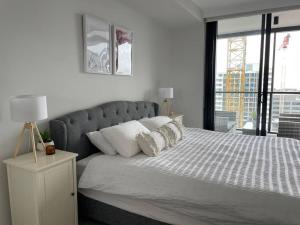 a bedroom with a large bed with a large window at Designer 1 BR Apt in Wollongong with Ocean Views in Wollongong