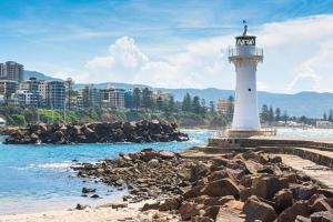 a lighthouse on the shore of a body of water at Designer 1 BR Apt in Wollongong with Ocean Views in Wollongong