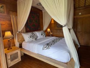 a bedroom with a bed with a canopy at Sirya Farm House in Meliling