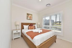 um quarto branco com uma cama grande e uma janela em Coolabah House - Tranquil Haven in Nulkaba em Nulkaba