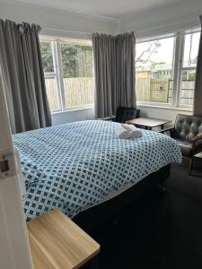 ハミルトンにあるHoliday Room in Chartwellのベッドとソファと窓のある寝室