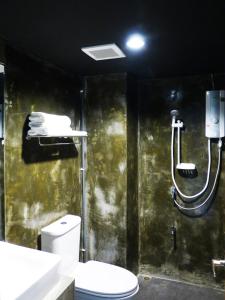a bathroom with a toilet and a shower at B+Arch House / Hotel&Cafe in Chiang Mai