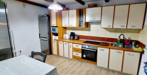 a kitchen with white cabinets and a sink and a stove at Casa Simion in Sibiu +45 photos