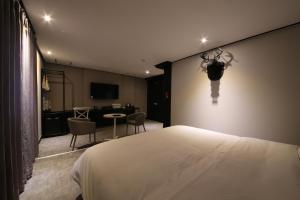 釜山にあるAlmond Hotel Gupo Stationのベッドルーム1室(ベッド1台、テーブル、椅子付)