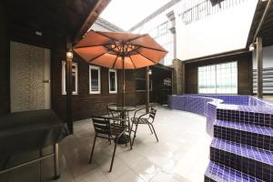 a patio with a table and chairs and an umbrella at Almond Hotel Gupo Station in Busan
