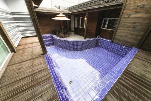 uma vista superior de uma piscina com azulejos azuis em Almond Hotel Gupo Station em Busan