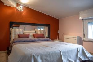 una camera da letto con un grande letto con pareti arancioni di APPARTAMENTO CAMPOVOLO a Reggio Emilia