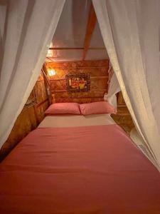 a small bedroom with a bed with a canopy at Remy's Nest in Tagaytay