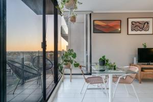 um apartamento com uma varanda com uma mesa e cadeiras em Ocean view apartment close to CBD with indoor pool. em Melbourne