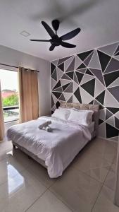 Un dormitorio con una cama y un ventilador de techo. en Honeyz Waterpark Homestay., en Ipoh