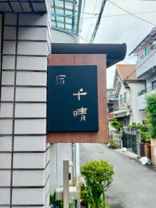 大阪市にあるGuest House TIHARU 6bedrooms12people max and Straight to USJ and Near the hot springの建物の側面にある看板